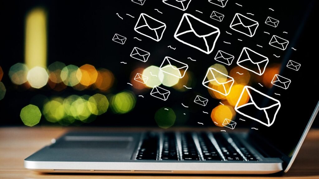 E-posta pazarlamasını temsil eden, laptop ekranından yayılan zarf ikonları.