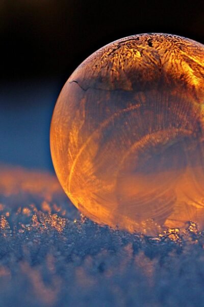 pexels-photo-302743-302743 Close-up shot of a frozen bubble with warm reflections resting on a snowy surface at twilight.